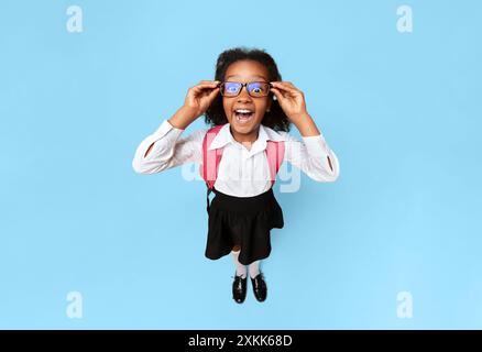 Black Schoolgirl urlando guardando la telecamera, High-Angle Studio Shot Foto Stock