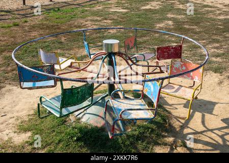 Rusty Vintage Merry-Go-Round in Abandoned Playground evoca nostalgici ricordi dell'infanzia Foto Stock