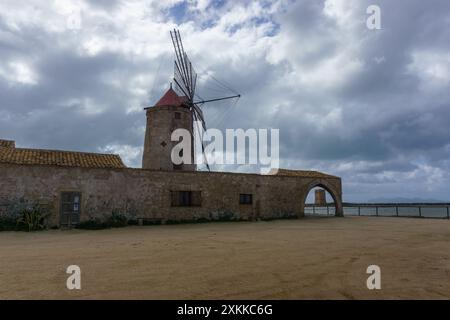 Museo del sale con mulino a vento nella riserva naturale delle Saline di Trapani con cielo nuvoloso sopra, Contrada Nubia, Sicilia, Italia Foto Stock
