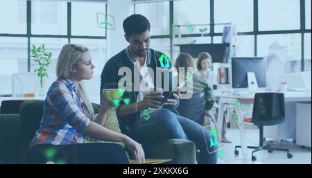 Immagine di icone ecologiche su diversi colleghi che utilizzano un tablet e discutono del lavoro in ufficio Foto Stock