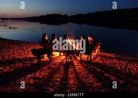 18.07.2020, Polonia, Wielkopolska, Lanken - persone sedute intorno a un fuoco sulle rive di Jezioro Gwiazdy. 00S200718D134CAROEX.JPG [VERSIONE MODELLO: N Foto Stock