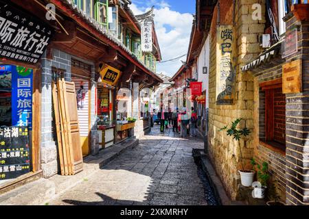 I turisti asiatici camminano nella città vecchia di Lijiang Foto Stock