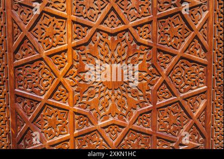 Decorazioni tradizionali asiatiche con motivi uzbeki su porte in legno intagliate in Uzbekistan da vicino Foto Stock