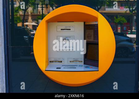 Tarragona, Spagna - 15 luglio 2024: Unica struttura circolare ATM gialla integrata in un ambiente urbano Foto Stock