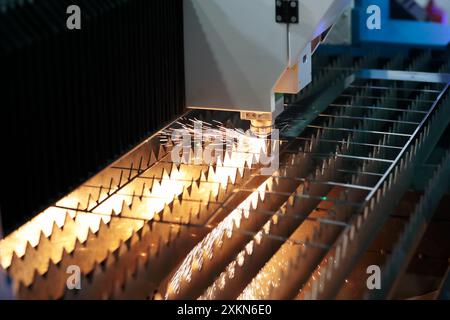 Processo di taglio automatico della lamiera con la macchina di taglio laser a fibra CNC industriale. Messa a fuoco selettiva. Foto Stock