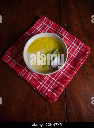 Vista dall'alto di panta bhat o pakhala o zuppa di riso fermentato con acqua, peperoncini verdi e cipolla in una ciotola. Cibo di base nell'India orientale. Foto Stock