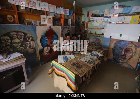 Un artista visivo palestinese Ahmed Muhanna dipinge dipinti all'interno del suo studio nel campo di Deir al-Balah Un artista visivo palestinese Ahmed Muhanna, dipinge dipinti all'interno del suo studio nel campo di Deir al-Balah, nella Striscia di Gaza centrale, il 24 luglio 2024. Al-Banna usa la carta delle scatole di cartone destinate a distribuire aiuti umanitari agli sfollati, per dipingere dipinti che esprimono la dura vita che i palestinesi vivono alla luce della continua guerra israeliana nella Striscia di Gaza. Foto di Naaman Omar apaimages Dair EL-Balah Striscia di Gaza territorio palestinese 240724 Dair El Balah NAA 0010 Copyright: xa Foto Stock