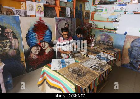 Un artista visivo palestinese Ahmed Muhanna dipinge dipinti all'interno del suo studio nel campo di Deir al-Balah Un artista visivo palestinese Ahmed Muhanna, dipinge dipinti all'interno del suo studio nel campo di Deir al-Balah, nella Striscia di Gaza centrale, il 24 luglio 2024. Al-Banna usa la carta delle scatole di cartone destinate a distribuire aiuti umanitari agli sfollati, per dipingere dipinti che esprimono la dura vita che i palestinesi vivono alla luce della continua guerra israeliana nella Striscia di Gaza. Foto di Naaman Omar apaimages Dair EL-Balah Striscia di Gaza territorio palestinese 240724 Dair El Balah NAA 009 Copyright: xap Foto Stock