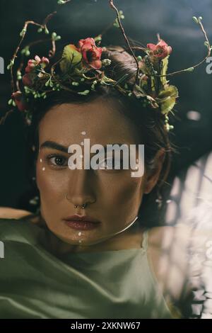 Una donna attraente con una corona floreale posa in una palude. Foto Stock