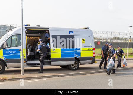 Londra, Regno Unito. 24 LUGLIO 2024. La polizia carica le prove su un furgone della polizia mentre Just Stop Oil tentava di violare il perimetro dell'aeroporto di Heathrow, gli attivisti non sono stati in grado di accedere alla pista e la polizia metropolitana ha confermato che 9 sono stati arrestati. A tre giornalisti, me compreso, è stato detto di non fotografare a causa di leggi aeroportuali, a seguito di una chiamata alla NUJ di Londra, i fotografi sono stati finalmente autorizzati a scattare una volta che la maggior parte dell'azione si era conclusa. Credito Milo Chandler/Alamy Live News Foto Stock