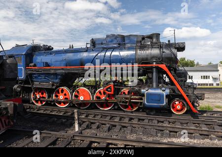 La locomotiva a vapore nera d'epoca con dettagli blu e rosso si trova sulla stazione ferroviaria centrale di Sortavala in una giornata estiva di sole Foto Stock