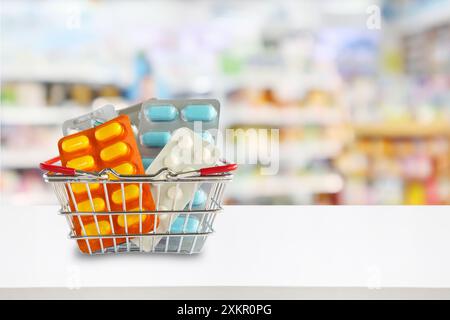 Pacchetto di pillole mediche nel carrello della spesa con gli scaffali della farmacia sfocati sullo sfondo Foto Stock