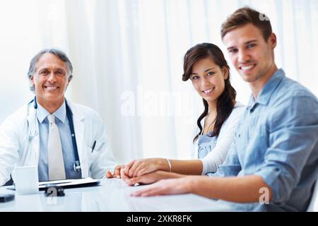 Medico anziano, ritratto e coppia per consultazione, assistenza sanitaria o consigli di fertilità in ospedale. Persone, ginecologo o medico professionale in Foto Stock