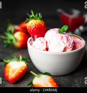 Gelato alla fragola servito in una ciotola con fragole fresche Foto Stock