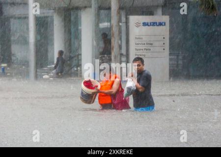 Quezon City, Filippine. 24 luglio 2024. I residenti attraversano le acque alluvionali di Quezon City, nelle Filippine, il 24 luglio 2024. Le Filippine sono state colpite dalle piogge ininterrotte del monsone sud-ovest potenziato portato dal tifone Gaemi, che ha fatto sì che il Consiglio della metropolitana di Manila dichiarasse lo stato di calamità nella regione della capitale nazionale mercoledì. Crediti: Rouelle Umali/Xinhua/Alamy Live News Foto Stock