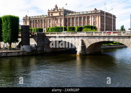 Vista su uno dei molti ponti di Stoccolma Svezia sul fiume Norrstrom da Piazza Adolf Gustav verso il complesso del Parlamento Riksdaghuset Foto Stock