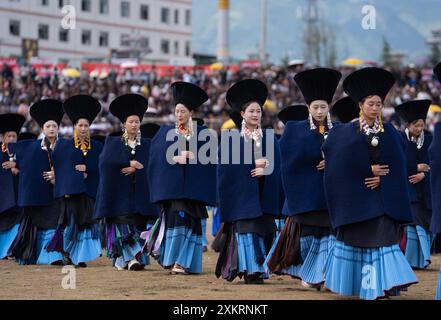 Butuo, la provincia cinese del Sichuan. 22 luglio 2024. La gente del posto vestita con costumi tradizionali Yi partecipa alla cerimonia di apertura del festival della torcia nella contea di Butuo, nella prefettura autonoma di Liangshan Yi, nella provincia del Sichuan, nella Cina sud-occidentale, il 22 luglio 2024. I residenti in costumi tradizionali del gruppo etnico Yi hanno partecipato al festival delle torce di quattro giorni che si è svolto dal 21 al 24 luglio. Crediti: Jiang Hongjing/Xinhua/Alamy Live News Foto Stock