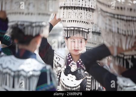 Butuo, la provincia cinese del Sichuan. 22 luglio 2024. Una donna vestita con il tradizionale costume Yi cammina in una strada nella contea di Butuo della Prefettura autonoma di Liangshan Yi, nella provincia del Sichuan nel sud-ovest della Cina, 22 luglio 2024. I residenti in costumi tradizionali del gruppo etnico Yi hanno partecipato al festival delle torce di quattro giorni che si è svolto dal 21 al 24 luglio. Crediti: Jiang Hongjing/Xinhua/Alamy Live News Foto Stock