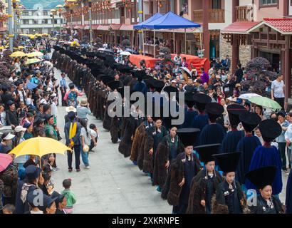 Butuo, la provincia cinese del Sichuan. 22 luglio 2024. La gente del posto vestita con i tradizionali costumi Yi sfilano su una strada durante il festival della torcia nella contea di Butuo, nella prefettura autonoma di Liangshan Yi, nella provincia del Sichuan, nel sud-ovest della Cina, 22 luglio 2024. I residenti in costumi tradizionali del gruppo etnico Yi hanno partecipato al festival delle torce di quattro giorni che si è svolto dal 21 al 24 luglio. Crediti: Jiang Hongjing/Xinhua/Alamy Live News Foto Stock