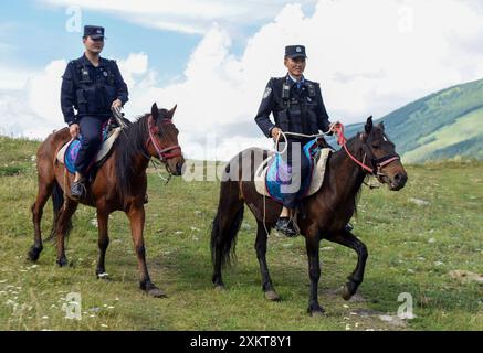 (240724) -- BURQIN, 24 luglio 2024 (Xinhua) -- agenti di polizia della stazione di polizia di frontiera di Kanas pattuglia a cavallo in aree inaccessibili da veicoli nella zona panoramica di Kanas ad Altay, nella regione autonoma di Xinjiang Uygur, nella Cina nord-occidentale, 22 luglio 2024. La stazione di polizia di confine di Kanas si trova nell'area panoramica di Kanas ad Altay. Negli ultimi anni, l'industria turistica di Altay si è sviluppata con vigore. Secondo gli agenti di polizia della stazione, l'area panoramica di Kanas riceve un massimo di 20.000 turisti al giorno. La stazione ha Unito le forze con la gente locale e il personale di spo scenica Foto Stock