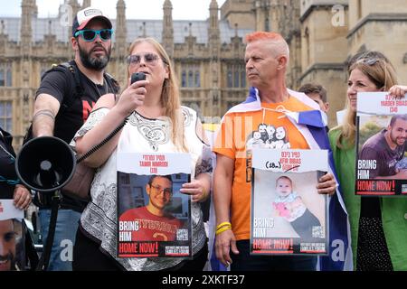 Londra, Regno Unito, 24 luglio 2024. Herut Nimrodi, madre del diciannovenne Tamir, si rivolge ai sostenitori riuniti nella piazza del Parlamento. Le famiglie di ostaggi rapite il 7 ottobre e portate a Gaza, hanno organizzato una manifestazione per chiedere il rilascio dei loro cari, in un rinnovato appello al governo laburista recentemente eletto. Le relazioni della famiglia Bibas, Guy Gilboa Dalal, tal Haimi e Tamir Nimrodi erano presenti come artista dal vivo spray-dipinto un'opera d'arte in solidarietà con tutti gli interessati. Credito: Fotografia dell'undicesima ora/Alamy Live News Foto Stock