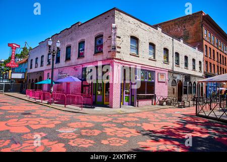 Vivace Doughnut Voodoo con edificio rosa e colorato sfondo in mattoni a Portland Foto Stock