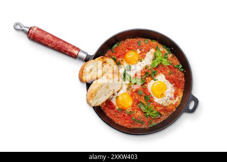Deliziosa colazione shakshuka in una padella. Posizione piatta. Isolato su sfondo bianco Foto Stock