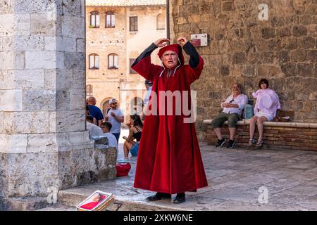 A Story Teller esegue "Dante's Divine Comedy" nella città collinare di San Gimignano, Toscana, Italia. Foto Stock