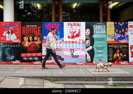 Uomo che cammina un cane pastposter che pubblicano gli spettacoli dell'Edinburgh Fringe Festival a George Square, Edimburgo, Scozia, Regno Unito. Foto Stock