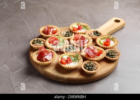 Deliziosi stuzzichini con jamon, pate e salsicce affumicate asciutte su un tavolo testurizzato grigio Foto Stock