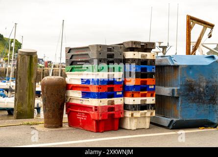 Casse di plastica per pesci e attrezzature da pesca sul molo nel porto di Ilfracombe Foto Stock