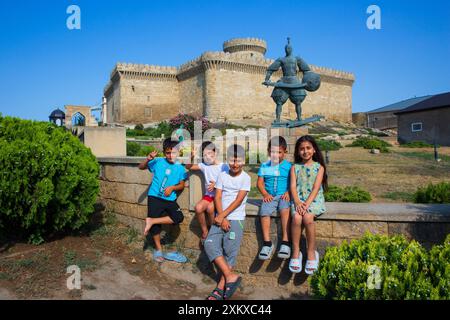 Bambini locali che posano fuori dal castello presso il complesso del Museo Archeologico ed Etnografico di Dubandi, Azerbaigian Foto Stock