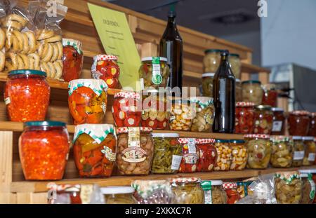 Scaffali in legno riempiti con verdure e frutta conservate in vari vasi esposti in un mercato locale, concetto di conservazione del cibo Foto Stock
