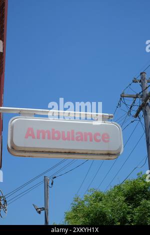 Cartello di ambulanza del nuovo Galles del Sud visto contro il cielo blu su un muro fuori da un deposito, garage a Marrickville, Sydney Foto Stock