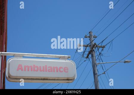 Cartello di ambulanza del nuovo Galles del Sud visto contro il cielo blu su un muro fuori da un deposito, garage a Marrickville, Sydney Foto Stock