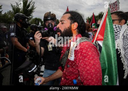 Washington DC, USA, USA, 24 luglio 2024. Un manifestante pro-palestinese si lava la faccia dopo essere stato spruzzato al pepe dalla polizia durante una protesta intorno al National Mall, Washington DC, USA, il 24 luglio 2024. Migliaia di persone sono riunite per dimostrazioni con una serie di richieste, tra cui il rilascio di ostaggi, il cessate il fuoco di Gaza e l'arresto del primo ministro israeliano Benjamin Netanyahu. Nel giorno in cui Netanyahu si rivolse al Congresso degli Stati Uniti a Washington, mentre cercava di rafforzare il sostegno degli Stati Uniti alla guerra del suo paese a Gaza. (Foto di Aashish Kiphayet/ Alamy Live News) Foto Stock