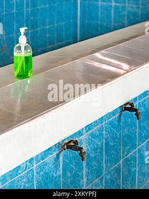 Una struttura Wadhu, uno spazio dedicato per il lavaggio rituale (wudu) prima della preghiera, un'area di abluzione per la pulizia e la purificazione, con file di wa piastrellati blu Foto Stock