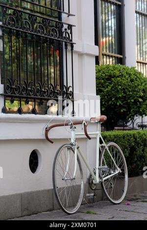 Bicicletta da strada bianca retrò di fronte al muro bianco Foto Stock