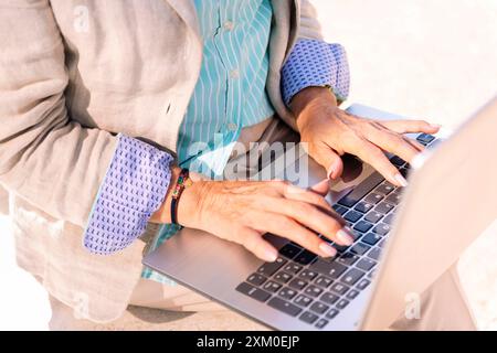 mani di una donna matura irriconoscibile che usa un notebook Foto Stock