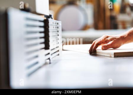 Falegname esperto che utilizza una fresa per superfici in un'officina affollata, realizzando pezzi di legno impeccabili. Interni vivaci pieni di profumo di legno mentre l'artigiano lavora Foto Stock