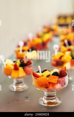 Concetto di cibo sano, mangiare pulito. Dolce dolce estivo a basso contenuto calorico. Semplice Macedonia di frutta fatta in casa in bicchieri, colazione ideale. Foto Stock