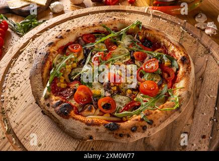 Gustosa pizza vegetariana cotta al forno su tagliere di legno Foto Stock