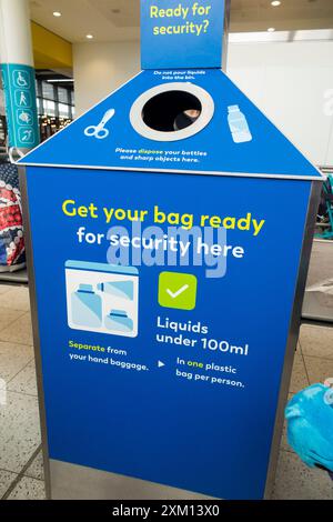 Contenitore per liquidi di scarto, liquidi, oggetti taglienti e taglienti, che mostra le regole sugli oggetti consentiti nel bagaglio a mano e attraverso la sicurezza. Aeroporto di Gatwick. REGNO UNITO. (138) Foto Stock