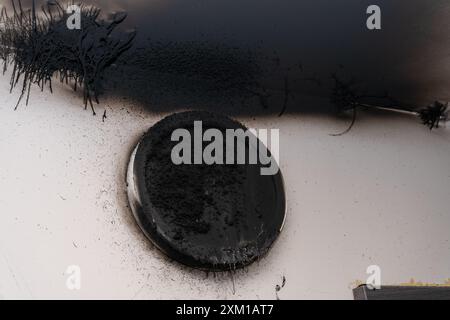 Lampada LED bruciata. Una lampada a paralume sulla parete dopo un incendio. Combustione spontanea e incendio in un edificio residenziale. Applique da soffitto interna Foto Stock