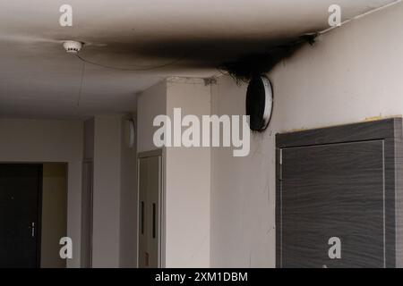 Lampada LED bruciata. Una lampada a paralume sulla parete dopo un incendio. Combustione spontanea e incendio in un edificio residenziale. Sensore di allarme antincendio interno. Porta Foto Stock