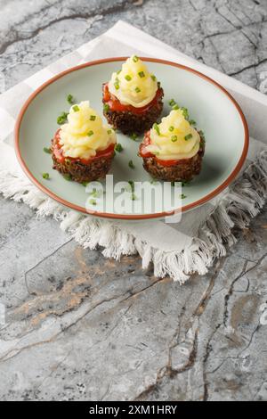 Cupcake con polpettone con salsa di pomodoro e purè di patate in primo piano in un piatto sul tavolo. Verticale Foto Stock