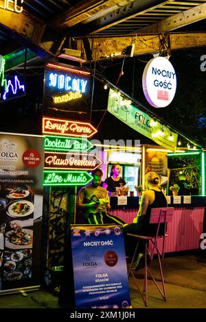 Insegne al neon e stand Folga x Nocny Gosc, mercato alimentare Nocny Market (mercato notturno) all'interno delle ex piattaforme della stazione ferroviaria centrale, Varsavia, Polonia Foto Stock