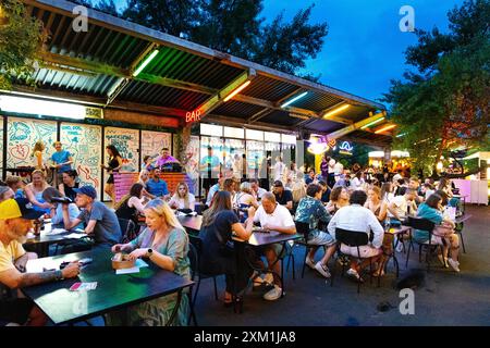 Persone che mangiano al mercato alimentare all'aperto di Nocny Market (mercato notturno) all'interno delle ex piattaforme della stazione ferroviaria centrale, Varsavia, Polonia Foto Stock