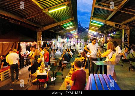 Persone che mangiano al mercato alimentare all'aperto di Nocny Market (mercato notturno) all'interno delle ex piattaforme della stazione ferroviaria centrale, Varsavia, Polonia Foto Stock