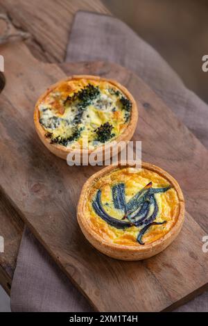 Gustate mini quiche di verdure su un tagliere su un tavolo di legno. Vista dall'alto. Foto Stock